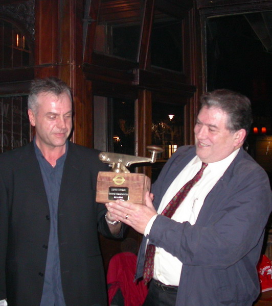 PP069_3.jpg - David S. BROWN *28 July 1945 - †February 2012  Presentation ceremony at his Farewell "do" in February 2004, the gift is a Master Controller from a train he used to drive years ago and has long since been scrapped. It is mounted on a piece of recovered railway sleeper from the track at one of the stations Dave later worked on  Any details, memories or photographs that you may have would be most welcome.