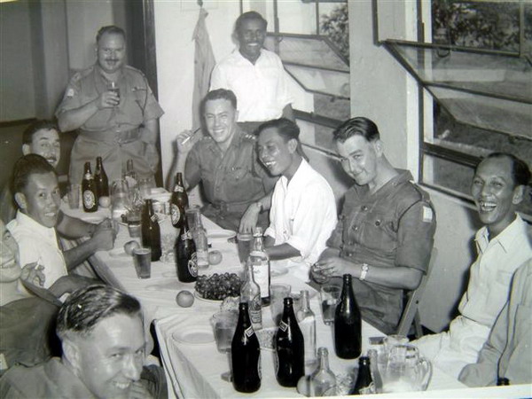 PM001p3.JPG - Maj. Ted Macey (with glass in hand at the head of the table) Christmas Party in the orderly room at Alexandra Barracks, Singapore - 1956   Any details, memories or photographs that you may have would be most welcome.